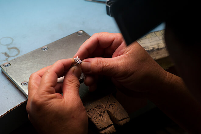 Jeweler working on ring repair at their bench.