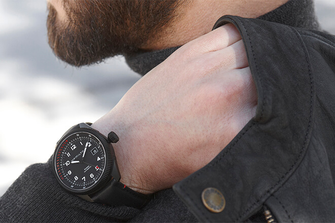 Man wearing an all-black Hamilton watch on his wrist.