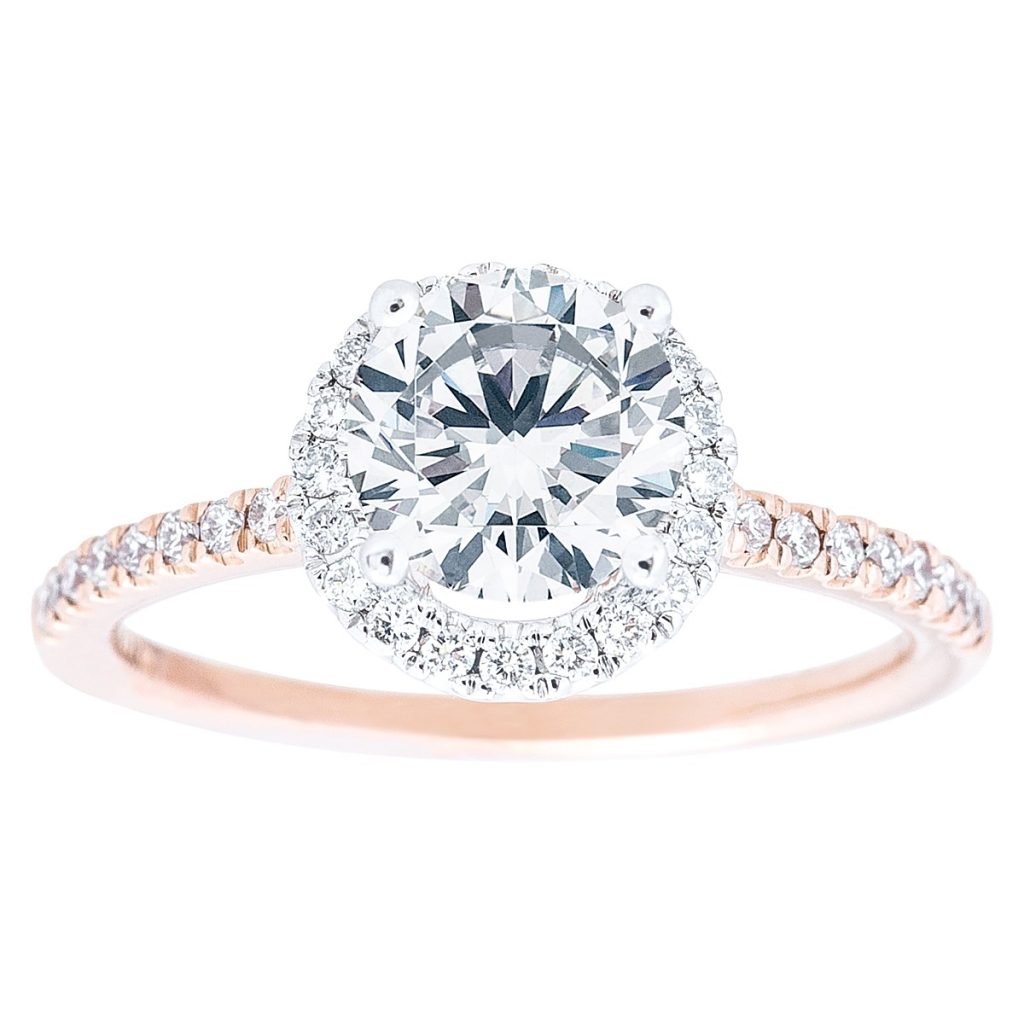 Rose gold diamond engagement ring with a diamond halo and diamonds in the band.