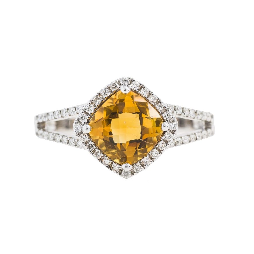 White gold ring centered with citrine surrounded by a diamond halo and diamonds in the split band.