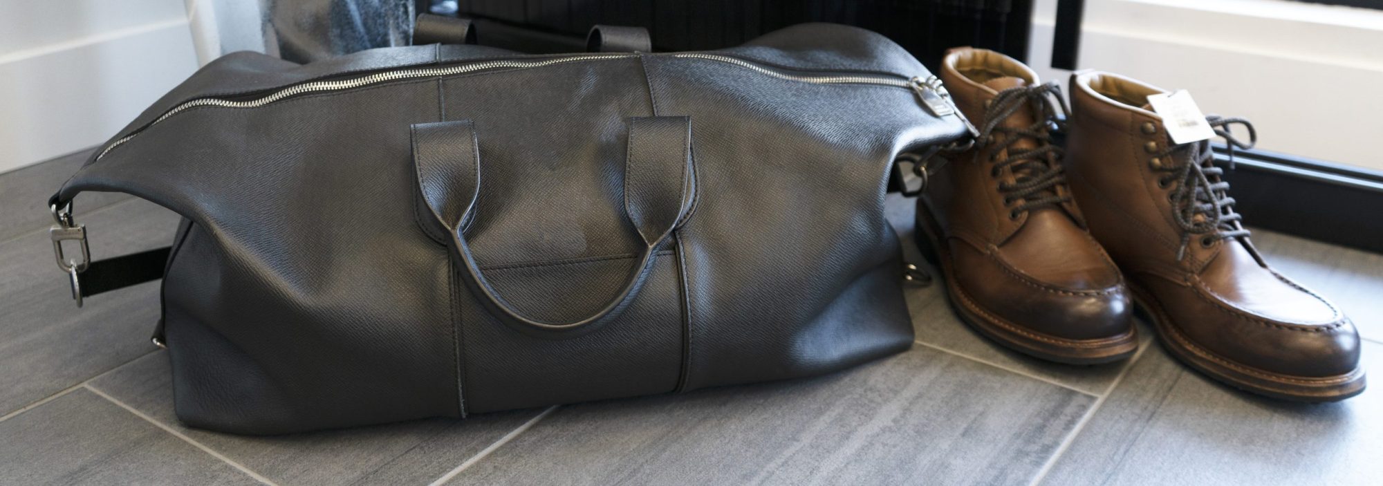 Vintage designer weekender bag and brown leather shoes.