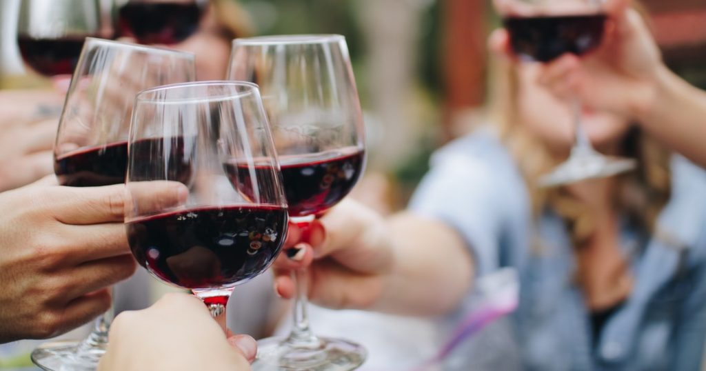 Group of friends cheering their wine glasses.