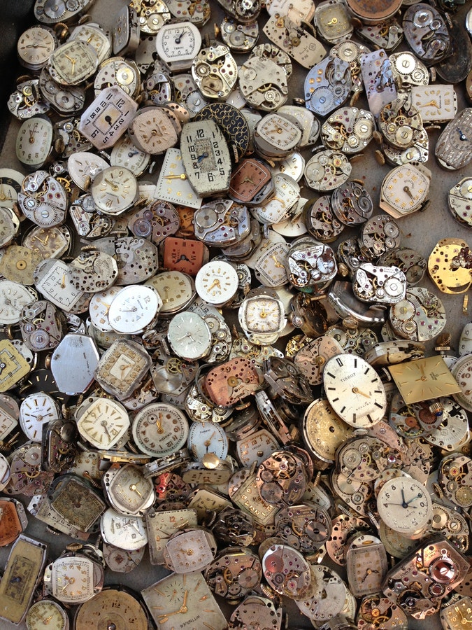 Pile of antique quartz movement watch faces removed from their cases.