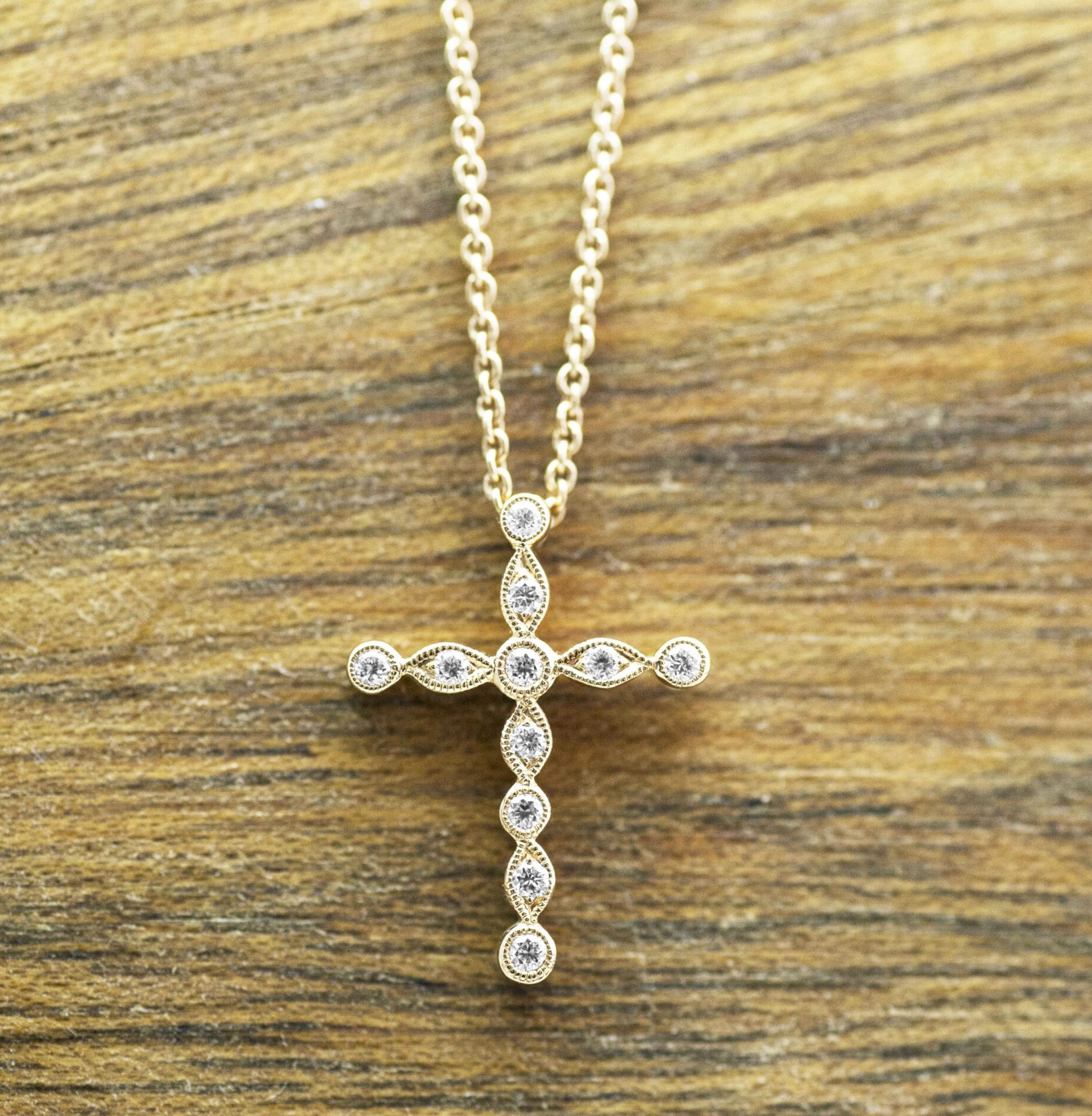 Yellow gold cross pendant set with diamonds.