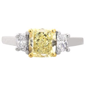 three stone engagement ring set with a yellow diamond