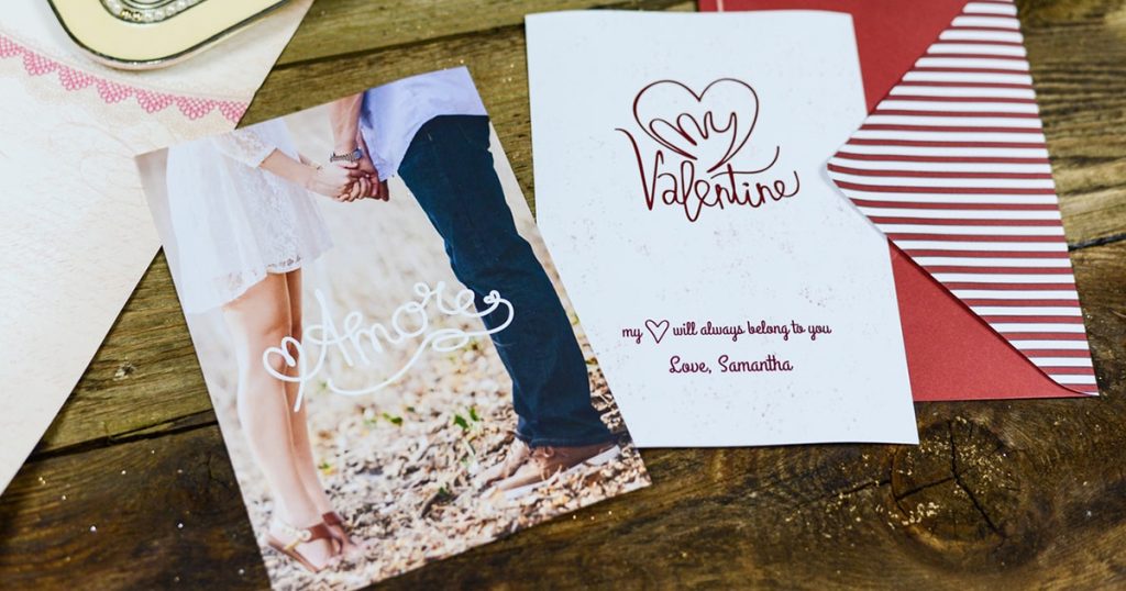 Various Valentine’s Day cards on wooden table.