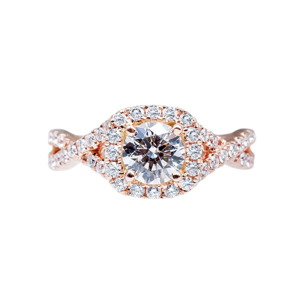 Rose gold twist diamond engagement ring with a diamond halo and diamonds in the
band.