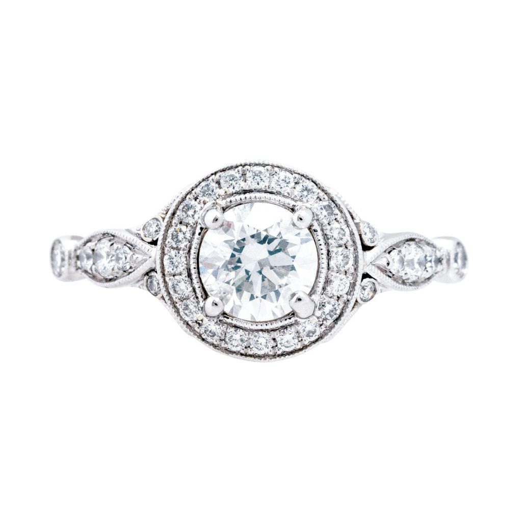 White gold engagement ring centered with a diamond surrounded by a diamond halo and
diamonds in the band.