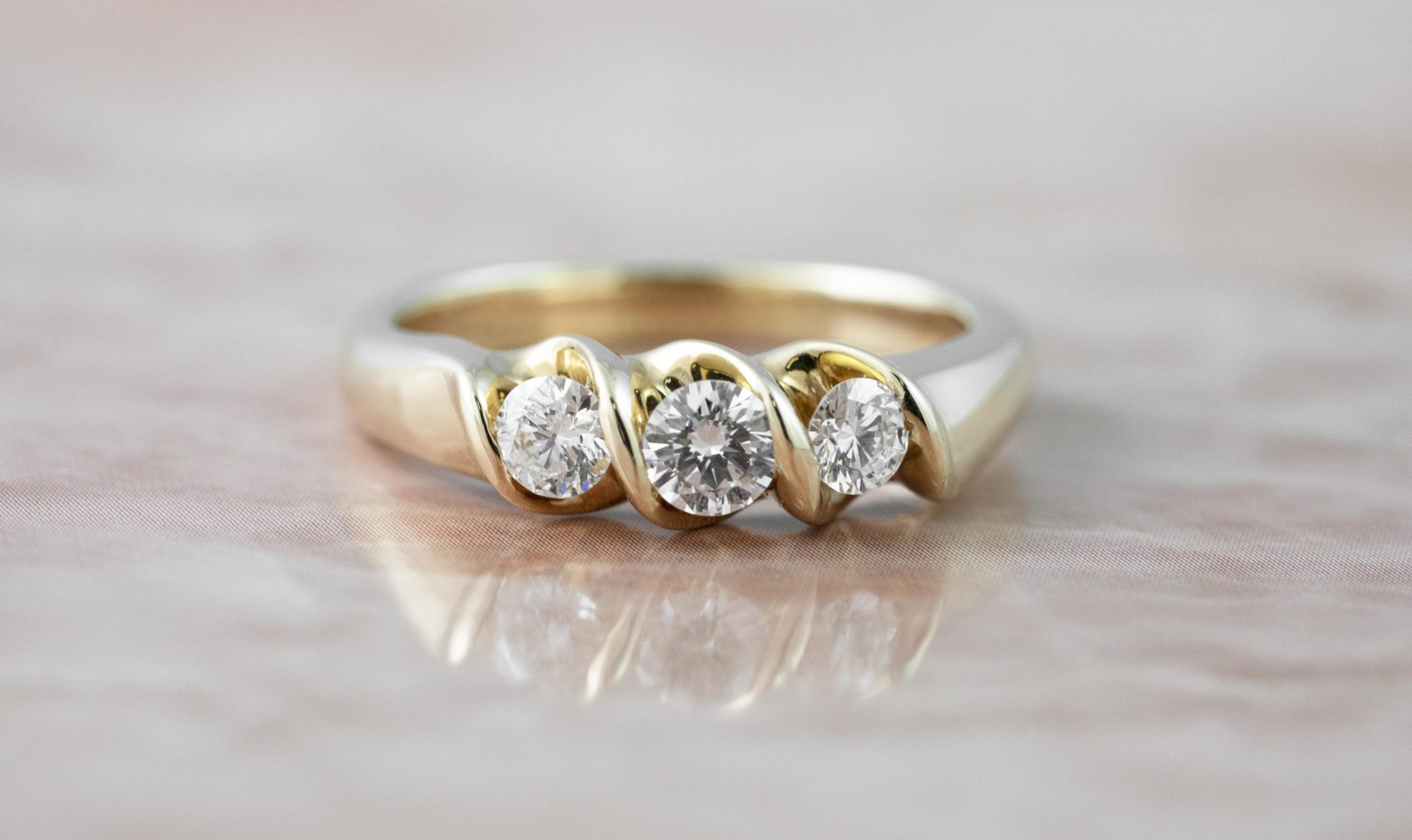 Yellow gold three-stone engagement ring set with diamonds.