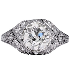 antique platinum ring set with a big centered diamond surrounded by small diamonds